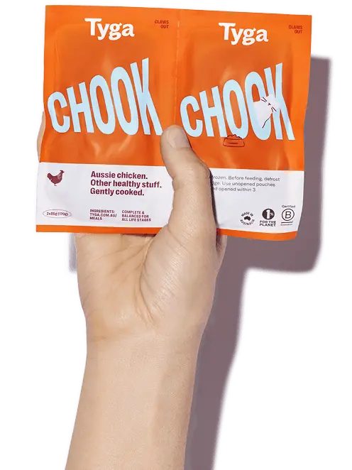 A hand holding a package of Tyga food